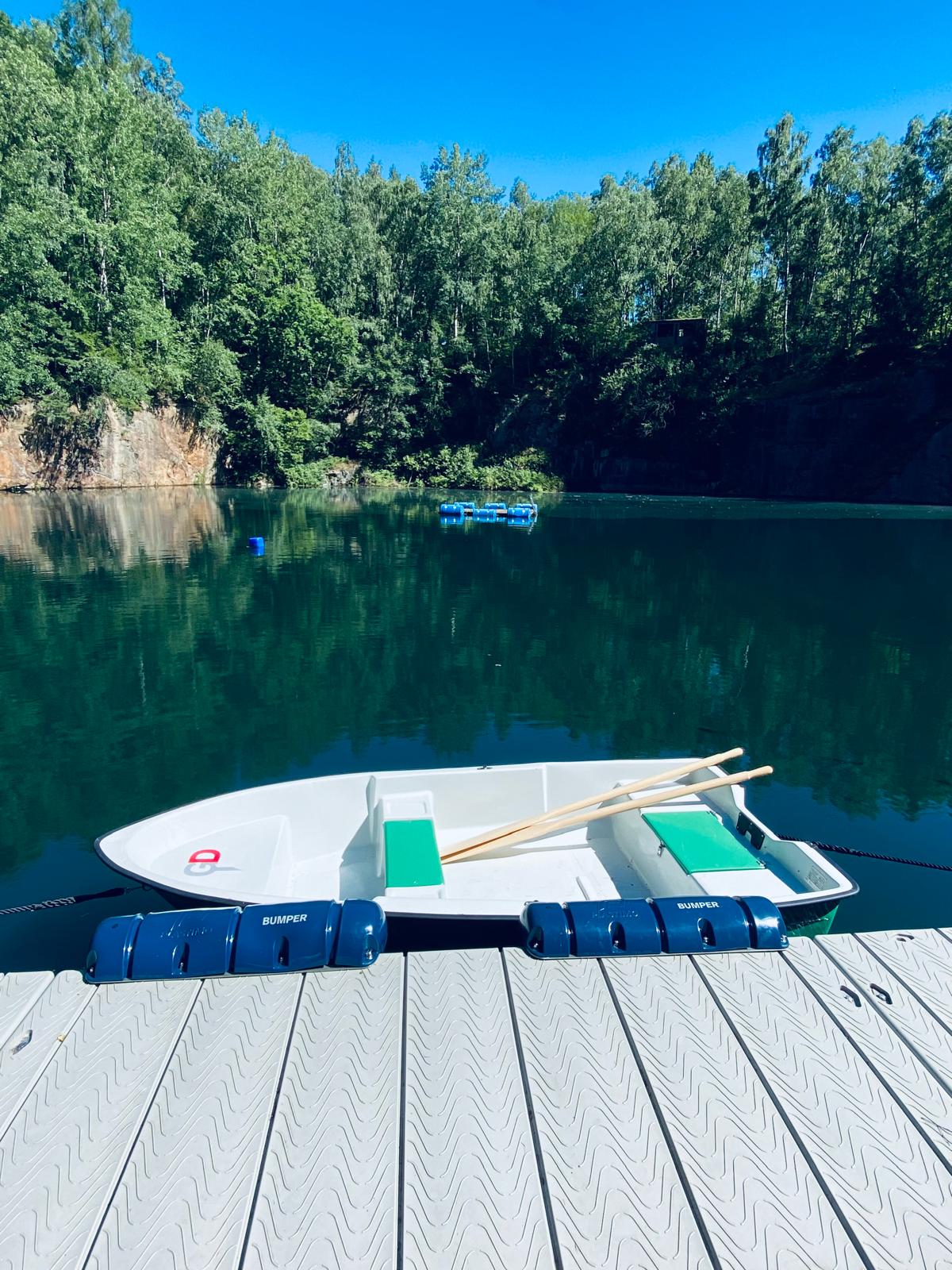 Paddelboot am Steg mit Steinbruch-Ausblick im Hintergrund